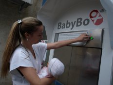 Zdravotní sestra předvádí odložení děťátka do babyboxu.