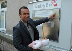Luděk Nečesaný, ředitel Krajské nemocnice Liberec, předvádí, jak se odkládá děťátko do babyboxu. 