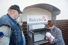 Senátorka Zdeňka Hamousová předvádí, jak se odkládá děťátko do babyboxu. 