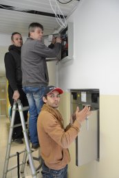 Zdeněk s asistenty Michalem a Radkem instalují babybox v interiéru nemocnice.