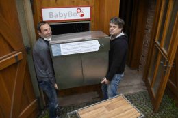 Starosta Ondřej Gros pomáhá Zdeňku Juřicovi při zasouvání babyboxu do montážního otvoru.