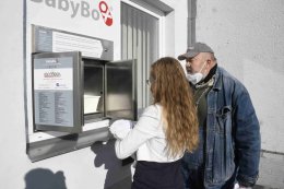 Pracovnice továrny předvádí, jak se odkládá děťátko.