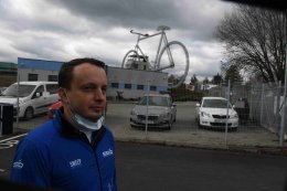 Tomáš Sedláček je obklopen obrovským kolem, dvěma letadly a spoustou artefaktů.