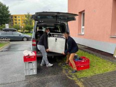 Asistenti Michal Drha a Radek Jetelina vynášejí babybox.