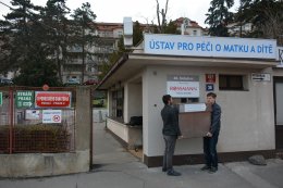 Zdeněk Juřica v pravo se svým asistentem vkládají babybox do rámu ve zdi.