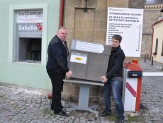 Josef Štajer a Zdeněk Juřica nesou nový babybox do připraveného montážního rámu.